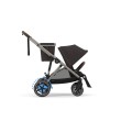 Wózek Cybex e-Gazelle w kolorze Chocolate Brown, widok z boku. Wózek jest skonfigurowany z siedziskiem spacerowym i dodatkowym koszem na zakupy, idealny do zakupów z dzieckiem.