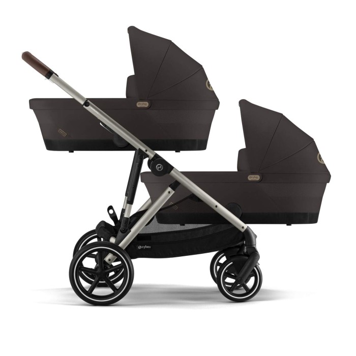 Wózek Cybex e-Gazelle w konfiguracji bliźniaczej 2w1, z dwiema gondolami i dwoma siedziskami obok. Wózek jest w kolorze Chocolate Brown.