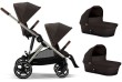Wózek Cybex e-Gazelle w konfiguracji bliźniaczej 2w1, widok z boku. Obok wózka znajdują się dwie gondole. Wózek jest w kolorze Chocolate Brown, z beżowym stelażem i brązowymi skórzanymi detalami.