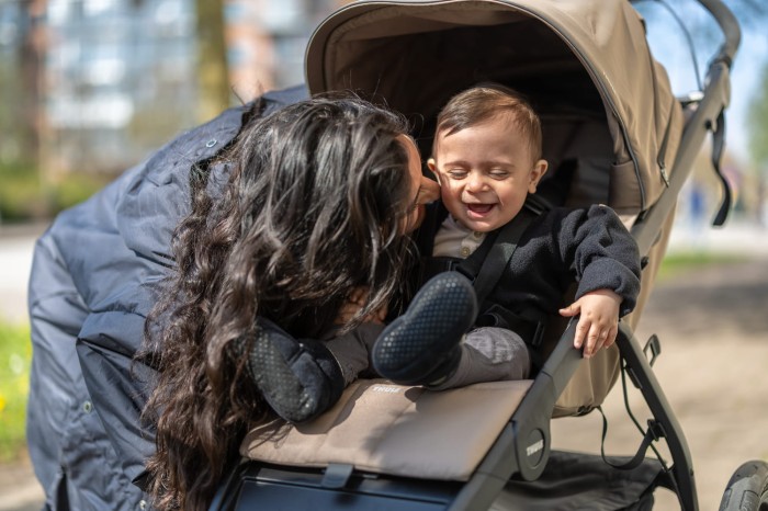 Mama z dzieckiem w wózku Thule Urban Glide 3 Tinted Taupe – komfortowy wózek spacerowy do miasta.